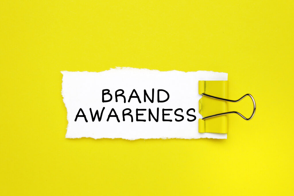 "Brand awareness" text written on a note with a binder clip.